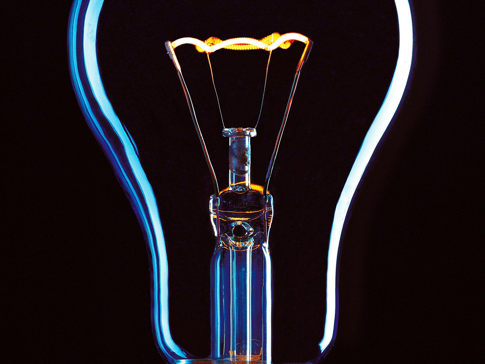 A single incandescent lightbulb glowing against a dark background, the kind of real clarity a performance review should create instead of just handing someone a number